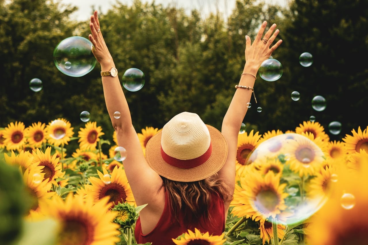 woman-in-field-of-sunflowers-with-bubbles